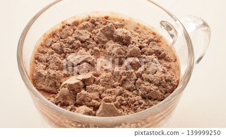 Close Up Chocolate Whey Protein Powder In Milk Before Mixing, Sports Nutrition And Supplement Drink Preparation Concept Close Up Chocolate Whey Protein Powder In Milk Before Mixing, Sports Nutrition And Supplement Drink Preparation Concept 139999250