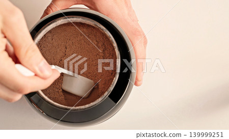 Top View Male Hands Scooping Chocolate Whey Protein Powder From Container, Fitness Nutrition And Supplement Routine Concept Top View Male Hands Scooping Chocolate Whey Protein Powder From Container, Fitness Nutrition And Supplement Routine Concept 139999251