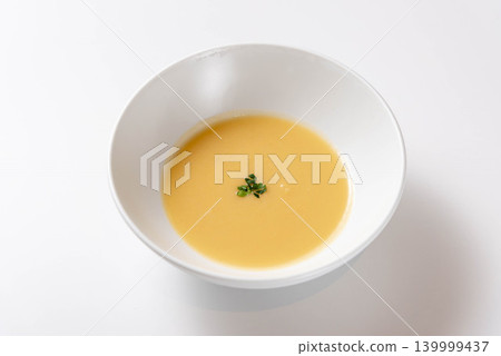 A warm, golden bowl of soup adorned with parsley floating in the broth. A warm, golden bowl of soup adorned with parsley floating in the broth. 139999437