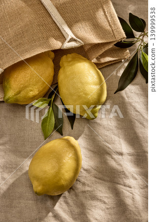 Fresh Italian Lemons Spilling from a Burlap Eco Bag on a Table. Top View 139999538