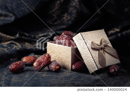 Dates in a gift box on black fabric with gold ornamentation. Dates in a gift box on black fabric with gold ornamentation. 140000024