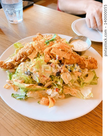 A hearty Mexican-style taco salad topped with crispy chicken and tortilla chips. 140000055