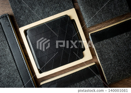 Handmade black wallet made of genuine leather on a wooden background. Close-up, top view. 140001081