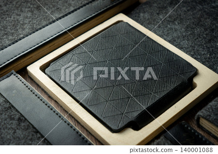 Handmade black wallet made of genuine leather on a wooden background. Close-up, top view. Handmade black wallet made of genuine leather on a wooden background. Close-up, top view. 140001088