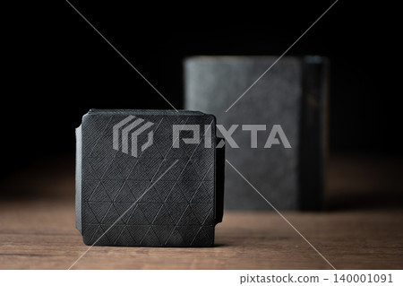 Handmade black wallet made of genuine leather on a wooden background. Close-up, top view. Handmade black wallet made of genuine leather on a wooden background. Close-up, top view. 140001091