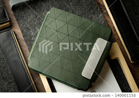 Handmade green wallet made of genuine leather on a wooden background. Close-up, top view. Handmade green wallet made of genuine leather on a wooden background. Close-up, top view. 140001158