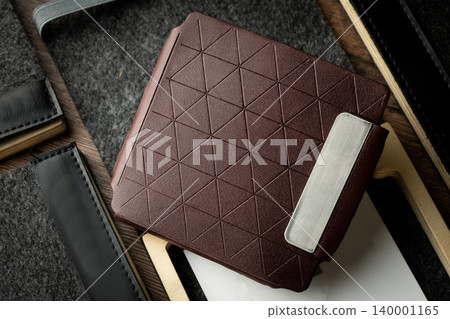 Handmade red brown wallet made of genuine leather on a wooden background. Close-up, top view. Handmade red brown wallet made of genuine leather on a wooden background. Close-up, top view. 140001165