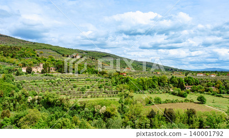 Stunning view of rolling hills with olive groves and historic buildings in Tuscany, Italy 140001792