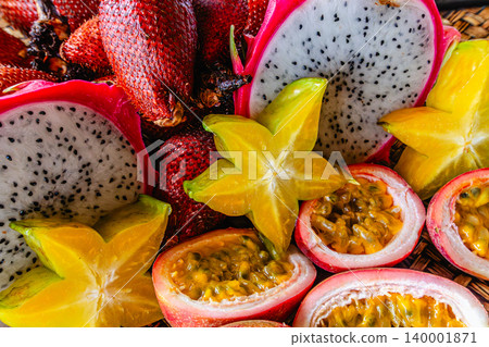 Colorful display of tropical fruits including dragon fruit, passion fruit, and star fruit 140001871
