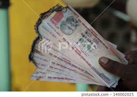 Burning Indian Currency closeup Burning Indian Currency closeup 140002025