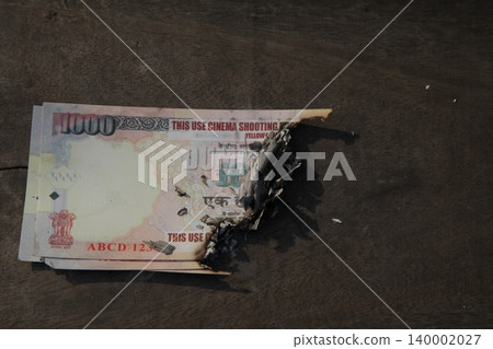 Burning Indian Currency closeup Burning Indian Currency closeup 140002027