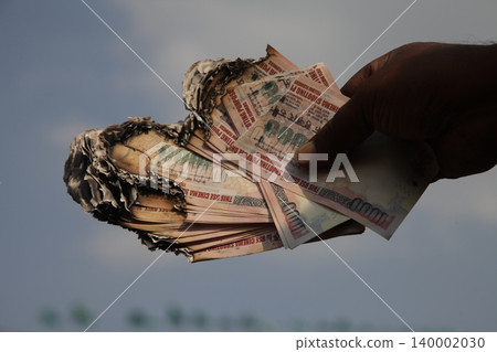 Burning Indian Currency closeup Burning Indian Currency closeup 140002030