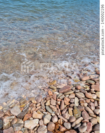 It is a beach with round pebbles. It is a beach with round pebbles. 140002196