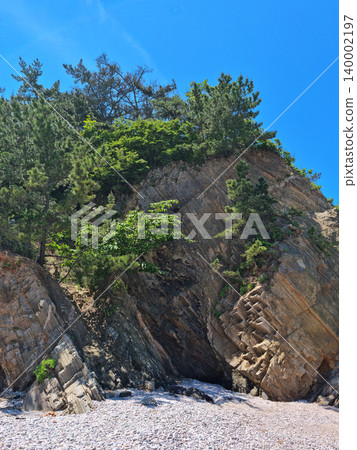 It is a beach with cliffs. 140002197