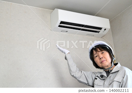 一名女工正在檢查空調機。 一名女工正在檢查空調機。 140002211