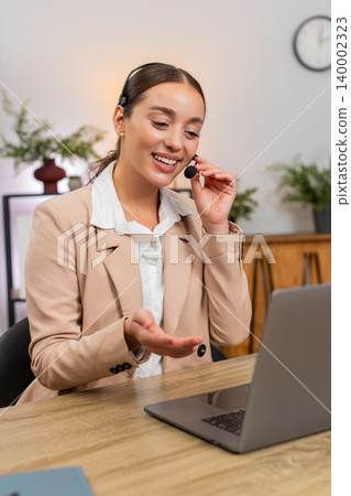 Young businesswoman with headset answers support call greets caller asks questions and stays polite Young businesswoman with headset answers support call greets caller asks questions and stays polite 140002323