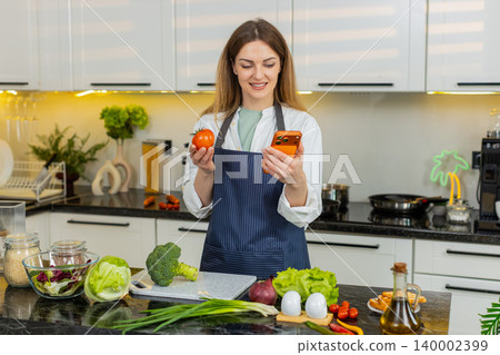 Middle-aged woman checking healthy grocery list on smartphone in home kitchen for diet meal planning 140002399