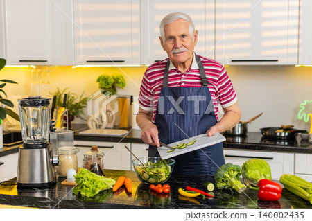 Senior old man mixing cucumber salad in home kitchen for diet plan and healthy nutrition lifestyle Senior old man mixing cucumber salad in home kitchen for diet plan and healthy nutrition lifestyle 140002435