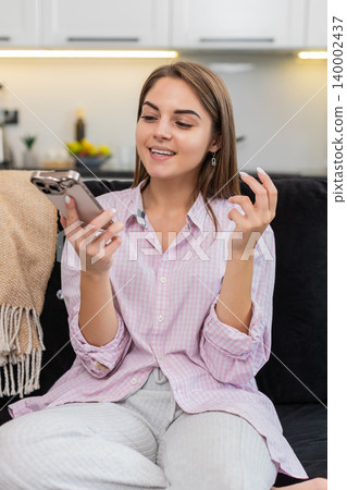 Young woman on smartphone speaker talks with friend or coworker listens nods and laughs during call Young woman on smartphone speaker talks with friend or coworker listens nods and laughs during call 140002437