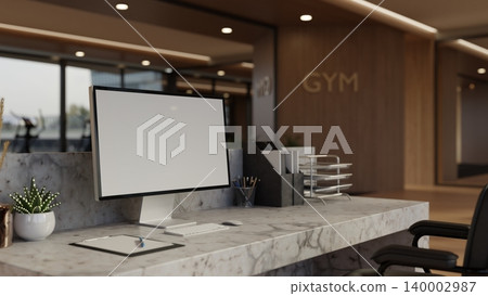 White screen laptop and clipboard on marble reception counter in a modern luxury fitness gym office. White screen laptop and clipboard on marble reception counter in a modern luxury fitness gym office. 140002987