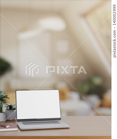 White screen laptop with notebook and potted plants on wooden countertop table in bright attic room. White screen laptop with notebook and potted plants on wooden countertop table in bright attic room. 140002999