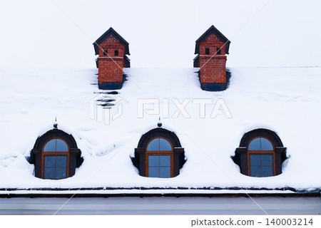 Snow covered roof with brick chimneys and arched dormer windows Snow covered roof with brick chimneys and arched dormer windows 140003214