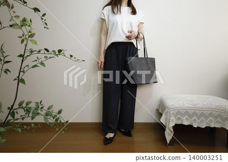 一位女士穿著休閒褲裝，打造商務造型；這種辦公室休閒風格展現了積極進取的工作形象。 140003251
