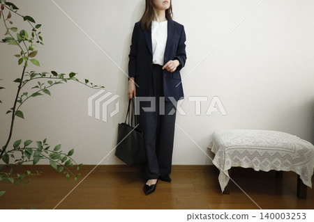 一位身穿休閒褲和海軍藍外套的女性——展現出積極工作且保持正直品格的形象。 一位身穿休閒褲和海軍藍外套的女性——展現出積極工作且保持正直品格的形象。 140003253