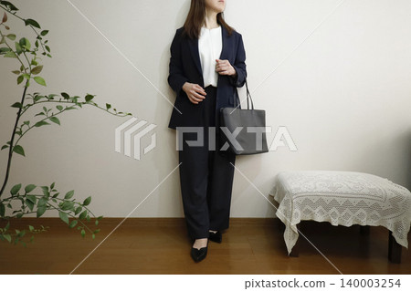 一位身穿休閒褲和海軍藍外套的女性——展現出積極工作且保持正直品格的形象。 140003254