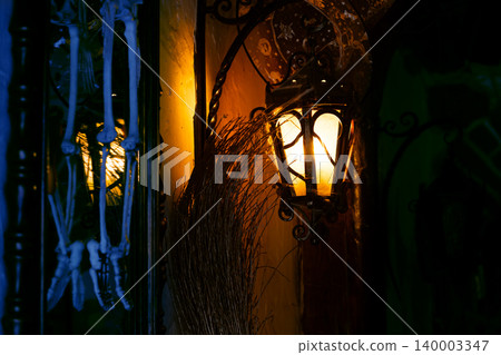 Spooky Halloween decoration with an aged lamp and hanging skeleton bones Spooky Halloween decoration with an aged lamp and hanging skeleton bones 140003347
