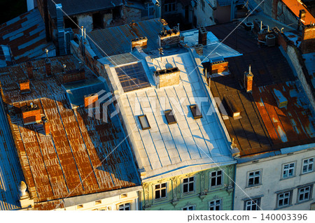 Aerial view of aged city rooftops with historical buildings and chimneys 140003396