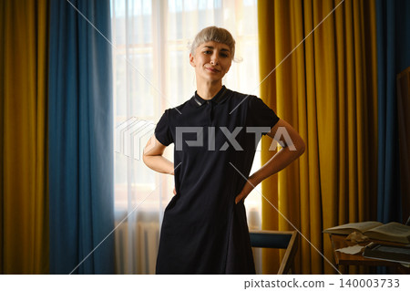 Woman stands confidently in room with colorful curtains during afternoon light Woman stands confidently in room with colorful curtains during afternoon light 140003733