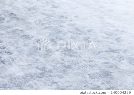 Snow-covered icy ground with packed snow and footprints Snow-covered icy ground with packed snow and footprints 140004239