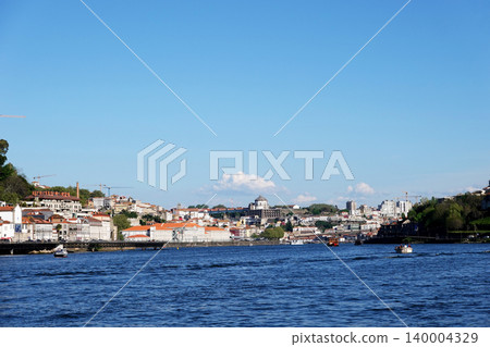 Wide panoramic view of Douro River and cityscape under blue sky in Porto, Portugal Wide panoramic view of Douro River and cityscape under blue sky in Porto, Portugal 140004329