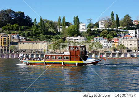 Traditional wooden cruise boat sailing on the Douro River in Porto, Portugal Traditional wooden cruise boat sailing on the Douro River in Porto, Portugal 140004457