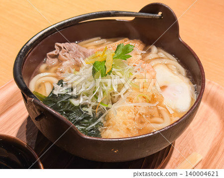 Japanese-style nabeyaki udon. Udon noodles simmered in a piping hot broth. Topped with shrimp tempura, seaweed, and egg. 140004621
