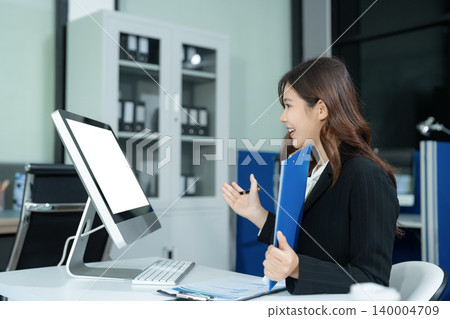 Asian businesswoman presenting ideas and analyzing financial charts during an online meeting. Asian businesswoman presenting ideas and analyzing financial charts during an online meeting. 140004709