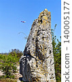 a tiny plane and a massive stone pillar at the Bulgarian Stone Desert landmark. 140005177