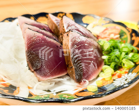 Warayaki katsuo no tataki is a specialty dish from Kochi Prefecture in Japan. It's a dish of seared bonito sashimi eaten with condiments. Warayaki katsuo no tataki is a specialty dish from Kochi Prefecture in Japan. It's a dish of seared bonito sashimi eaten with condiments. 140005185