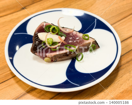 Warayaki katsuo no tataki is a specialty dish from Kochi Prefecture in Japan. It's a dish of seared bonito sashimi eaten with condiments. Warayaki katsuo no tataki is a specialty dish from Kochi Prefecture in Japan. It's a dish of seared bonito sashimi eaten with condiments. 140005186