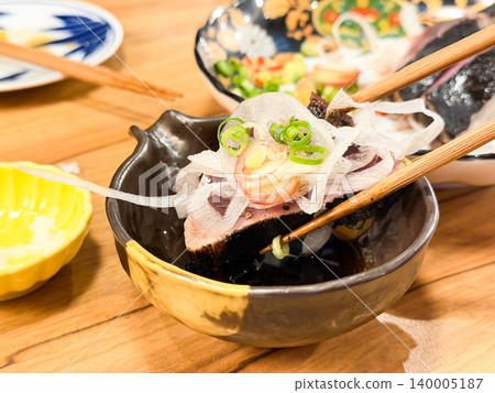Warayaki katsuo no tataki is a specialty dish from Kochi Prefecture, Japan. It's a dish of seared bonito sashimi served with condiments. (The location of the dish is unclear.) 140005187