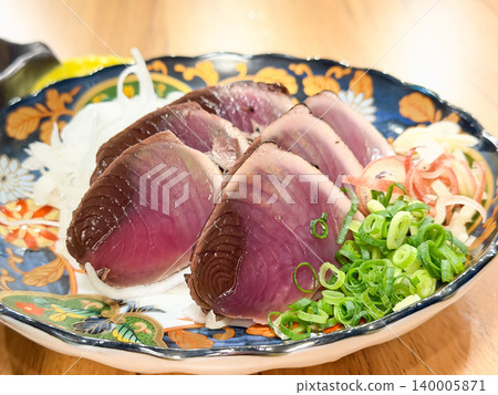 菓燒鰹魚刺身是日本高知縣的特色菜,是將鰹魚刺身炙烤後佐以調味食用的菜餚。 菓燒鰹魚刺身是日本高知縣的特色菜,是將鰹魚刺身炙烤後佐以調味食用的菜餚。 140005871