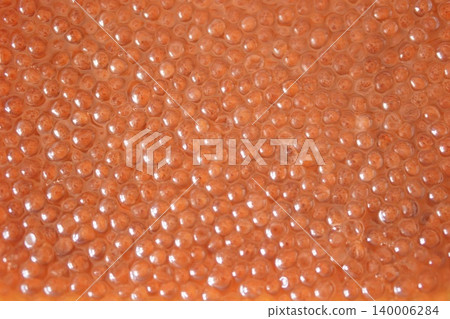 A vibrant, textured background image of salmon roe grains. 140006284