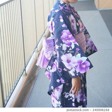 A child in a yukata (summer kimono) from behind; a Japanese summer festival image of Japanese culture; a person photograph. A child in a yukata (summer kimono) from behind; a Japanese summer festival image of Japanese culture; a person photograph. 140006288