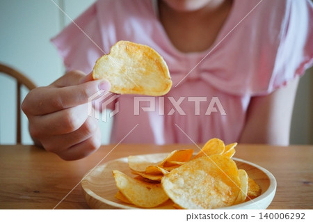 一張孩子享用薯片零食和正餐的照片。 一張孩子享用薯片零食和正餐的照片。 140006292