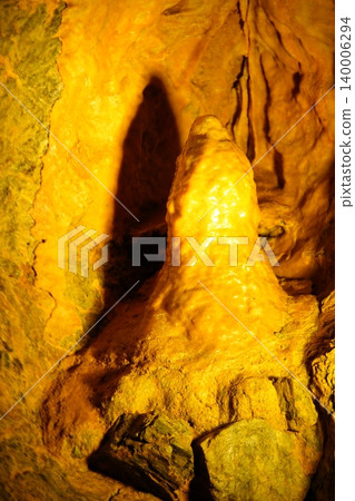 Photographs showcasing the mystical rock formations of a limestone cave and the natural scenery inside the cave illuminated by light. 140006294