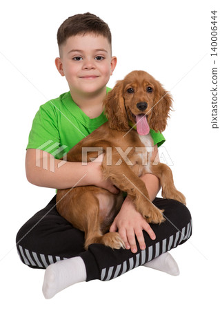 Happy young boy sitting cross-legged holding a puppy Happy young boy sitting cross-legged holding a puppy 140006444