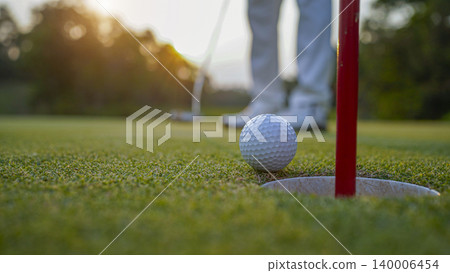 Golfers are putting golf in the evening golf course golf backglound. 140006454