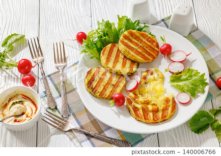 grilled cheese rounds on a plate with radishes 140006766
