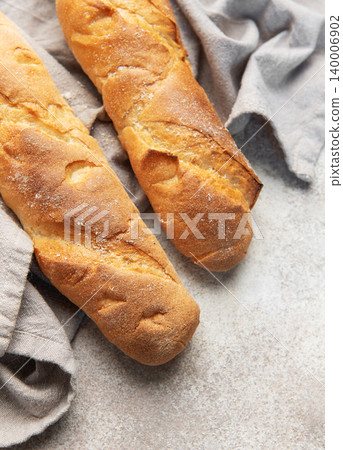 Fresh crisp baguettes on rustic linen cloth Fresh crisp baguettes on rustic linen cloth 140006902